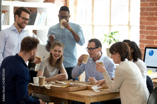 Cuadros en Lienzo Multi-ethnic employees group enjoy takeaway food friendly conversation in office
