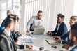 © alfa27 - Happy optimistic middle-aged athletic business owner leading his team. Confident successful businessman and his multiracial colleagues in background. Successful team concept