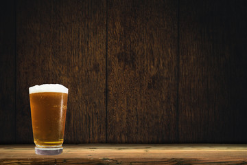 Poster - Glass of beer on a old oak table and background