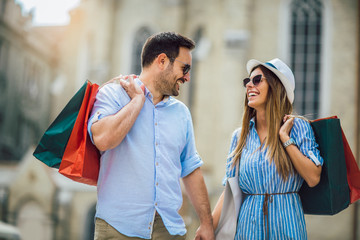 Wall Mural - Beautiful young couple enjoying in shopping, having fun in the city