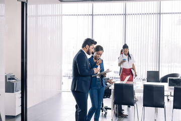 Multiracial, business people talking in break, communicate and have consultation with the application form in hand standing near window.