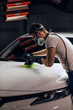 © alfa27 - mechanic using a modern car polisher. close up side view photo. copy space