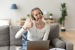 © fizkes - Smiling woman wearing headset showing thumbs up looking at camera