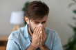Sick man got flu allergy sneezing in handkerchief blowing nose