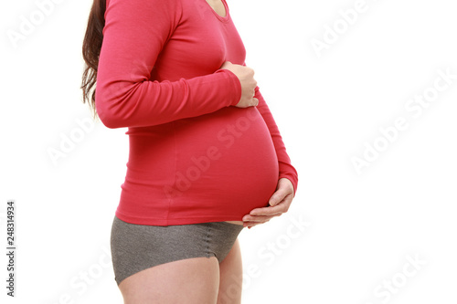 お腹を触る赤いシャツを着た臨月の妊婦 Stock Photo Adobe Stock お腹を触る赤いシャツを着た臨月の妊婦 Stock Photo Adobe Stock
