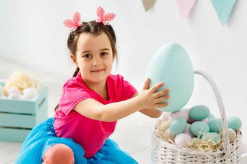 Wall Mural - Cute little girl and huge easter eggs