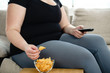 lack of physical activity, sedentariness, imbalanced nutrition, laziness, homebody. fat woman overeating junk food