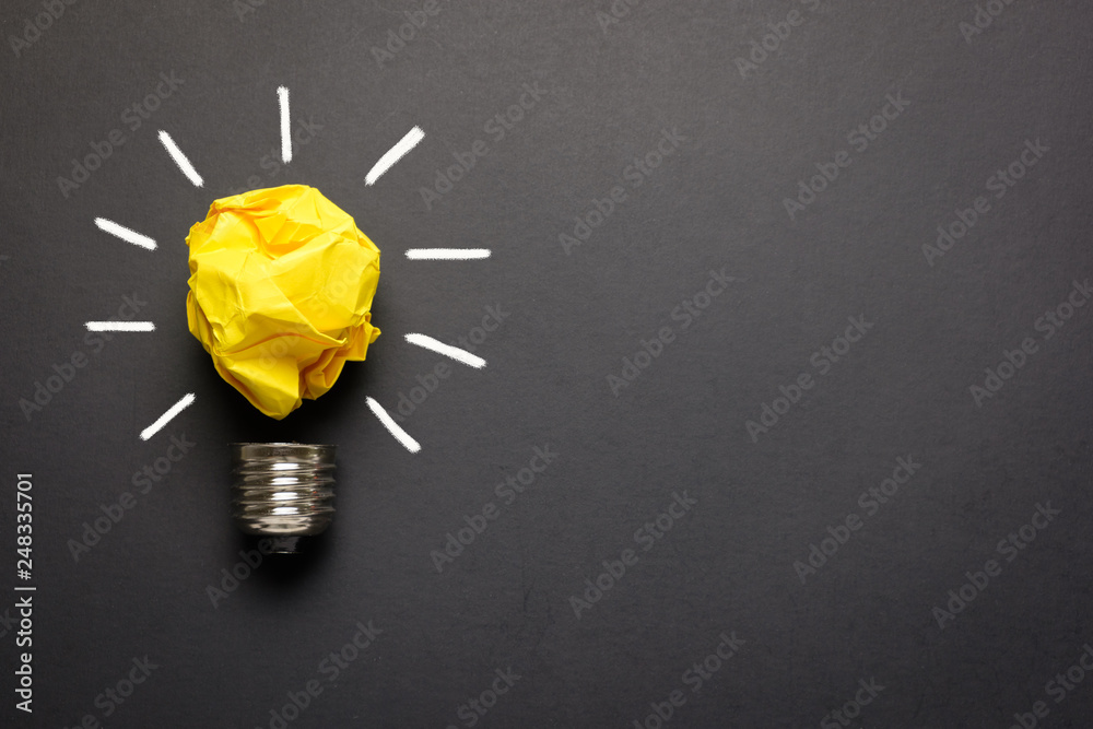 Great idea concept with crumpled yellow paper light bulb isolated on dark background - obrazy, fototapety, plakaty 