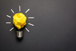 Great idea concept with crumpled yellow paper light bulb isolated on dark background