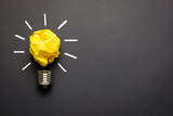 Great idea concept with crumpled yellow paper light bulb isolated on dark background