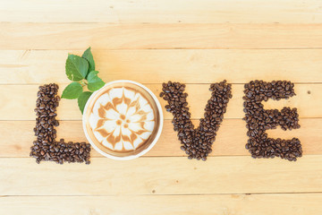 hot cappuccino with nice milk pattern and coffee bean LOVE text / coffee with love 