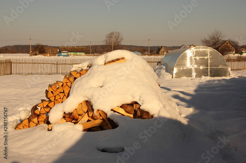 A Lot Of Chopped Fire Wood Under The Snow On The Background Of The
