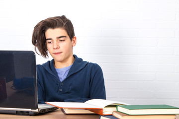 Canvas Print - young man with computer and books on the desk studying