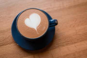 cappuccino with milk foam in a heart shape on wooden background.copy spase