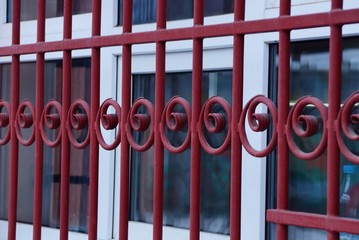 Poster - metal texture of red forged rods with a pattern on the window