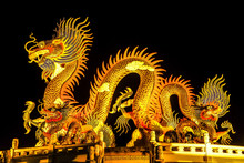 The Chinese Style Golden Statue Of A Magnificent Golden King Dragon With Light Up Illuminated At Night.