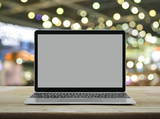 Fototapeta Panele - Modern laptop computer with blank grey screen on wooden table over blur light and shadow of shopping mall