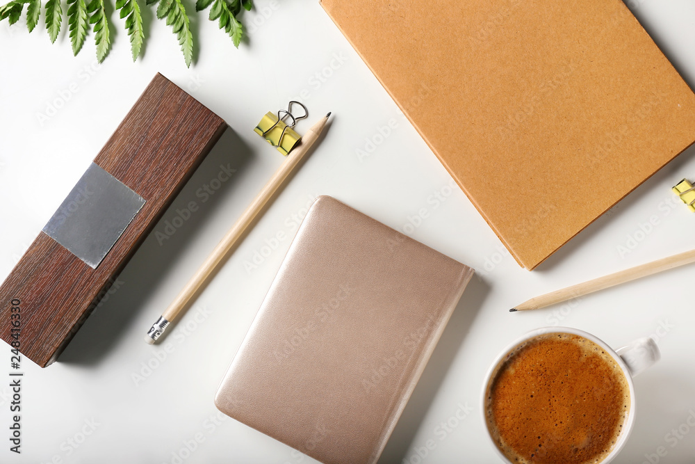 Stylish stationery with cup of coffee on white background