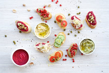 Variety Of Toasts Or Bruschetta On White Background. Beetroot, Avocado And Hummus Sauce. Flat Lay