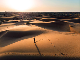 Wall Mural - Woman enjoying the desert sunset aerial