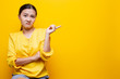 © chajamp - Woman show disgust gesture isolated over yellow background