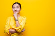 © chajamp - Happy woman thinking and standing isolated over yellow background