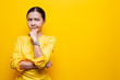 Woman feel confused isolated over yellow background
