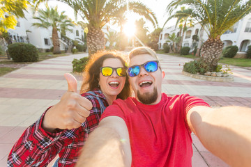 Wall Mural - Travel, vacation, summer and holiday concept - Happy couple taking selfie outdoors