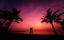 Silhouette Of Couple On Tropical Beach During Sunset On Background Of Palms And Sea
