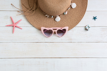 Wall Mural - Beach hat with travel items on white wooden background, Summer vacation concept