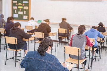 Wall Mural - behind group of asian high school, university student having test exams for taking writing examinati