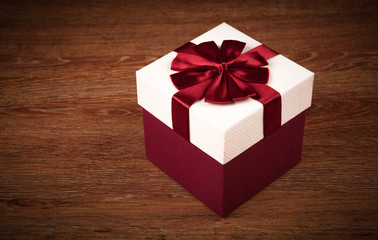 Wall Mural - white box with red bow on a wooden background