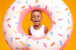 © Anatoliy Karlyuk - Enjoyment, fun, joy and happiness concept. Cheerful overjoyed dark skinned little boy feeling excited, going to beach with his father, laughing out loud, posing in studio with inflatable circle
