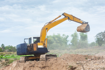 Wall Mural - Yellow excavator machine working earth moving works at construction site