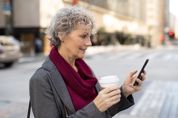 Sticker - Mature woman in city walking texting on cell phone