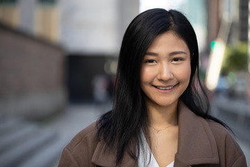 Canvas Print - Young Asian woman in city smile happy face portrait