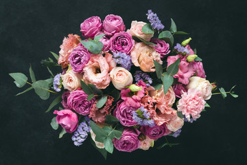beautiful bouquet of pink purple peonies, roses and eucalyptus isolated on black background. top vie