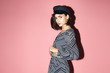 © Sergey Chumakov - young fashion woman in black and white contrast dress and vintage cap on pink background