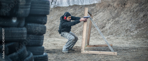 Fotografía Combat gun tactical shooting behind and around cover or barricade
