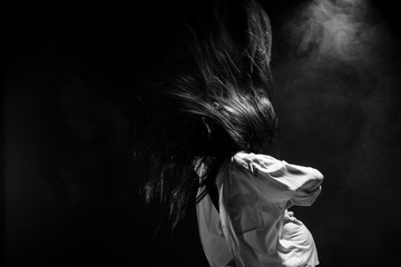 White Smoke Tan Skin Asian Woman black straight hair with Dense Fluffy Puffs of Fog on dark Background, Abstract high low exposure contrast, copy space for text logo, broken heart lonely girl can cry