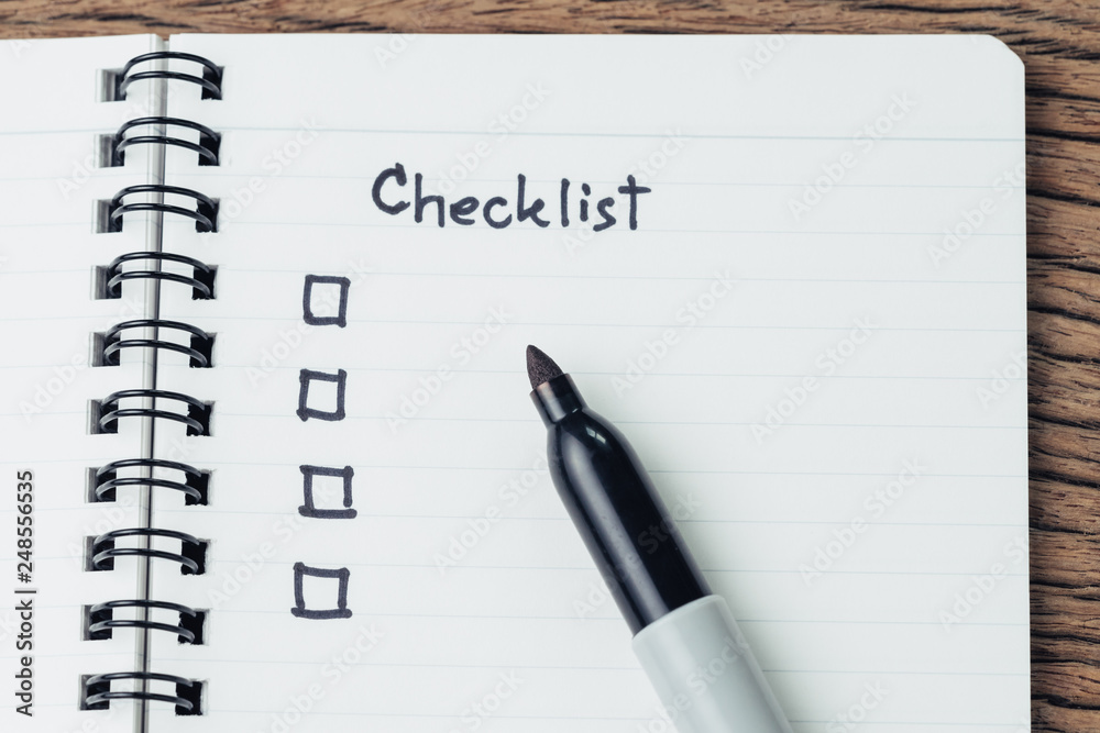 Checklist with marker pen and check box on small notepad on wood table ...