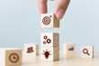 © Monster Ztudio - Concept of business strategy and action plan. Businessman hand putting wood cube block on top with icon