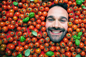 Fototapete - Mann mit Tomaten , Konzept für lebensmittelindustrie. Gesicht von lachenden mann in Tomaten flache.