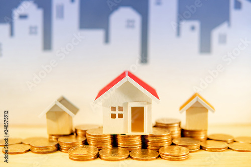 Real Estate Or Property Investment Concept Home Mortgage Loan Rate - home mortgage loan rate gold coins stack and house models on the table with white city skyline background saving money for future retirement