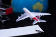 © NIKCOA - Travel concept. Cheque book,shopping cart,airplane and globe model with dark background. Business trip and travel for shopping online and paycheck concept.