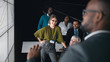 © JonoErasmus - Black african businessman giving a presentation at a business conference to group. Large video screen with charts and graphs in front of him and team