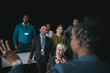 © JonoErasmus - Black african businesswoman giving a presentation at a business conference. Pointing at a large video screen next to her