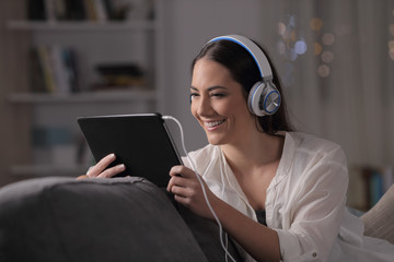 Wall Mural - Happy woman watching and listening tablet content