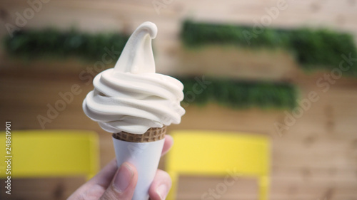 Fotografía Hand is holding soft serve ice cream cone.
