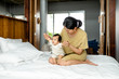 © LUMINA IMAGES - Beautiful Asian woman sitting on a bed and holding her baby.